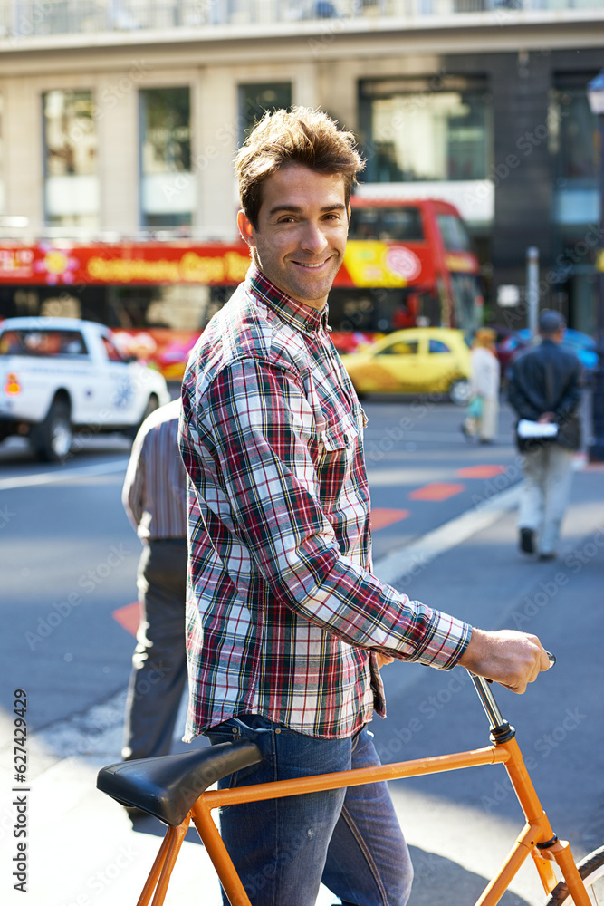 Feeling good about this day. Portrait of a handsome man traveling by bicycle in the city.