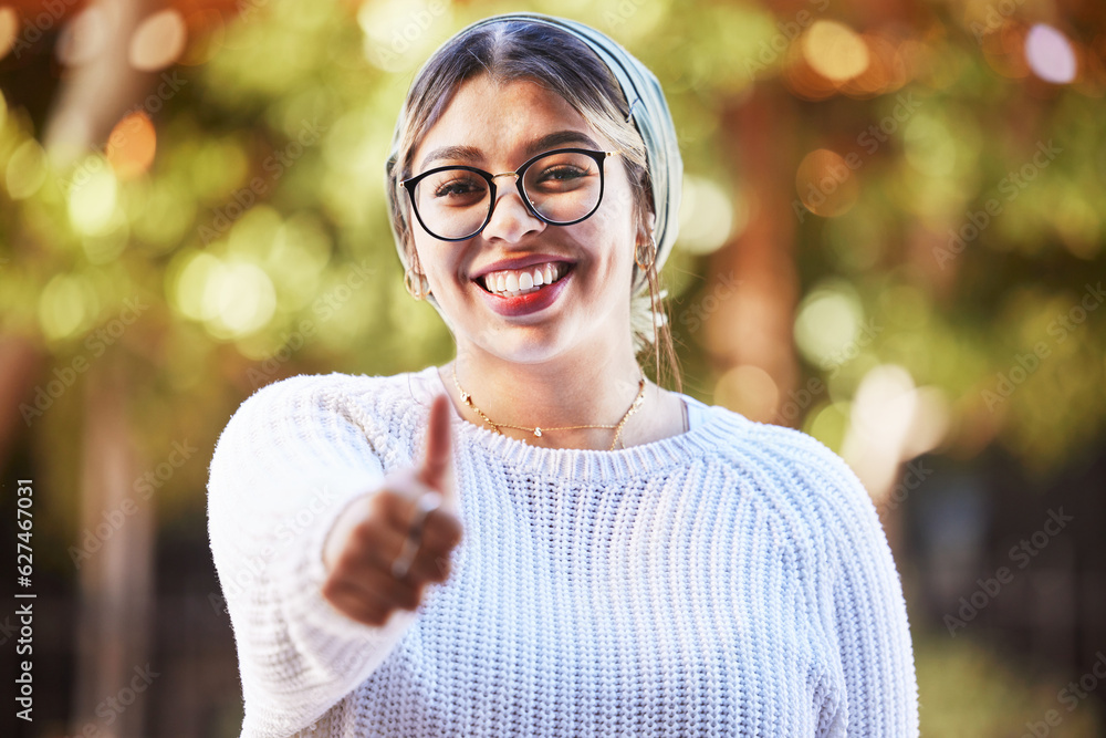 Young woman, thumbs up in portrait and smile, agreement and yes emoji with like sign and happiness. 