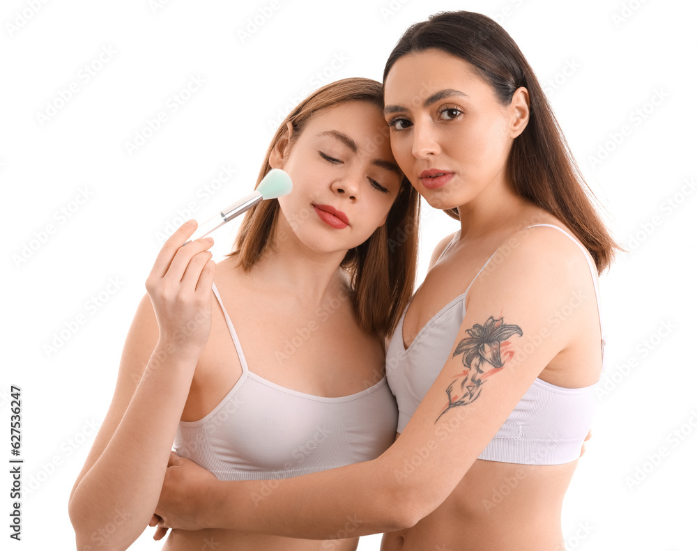Young women with makeup brush on white background