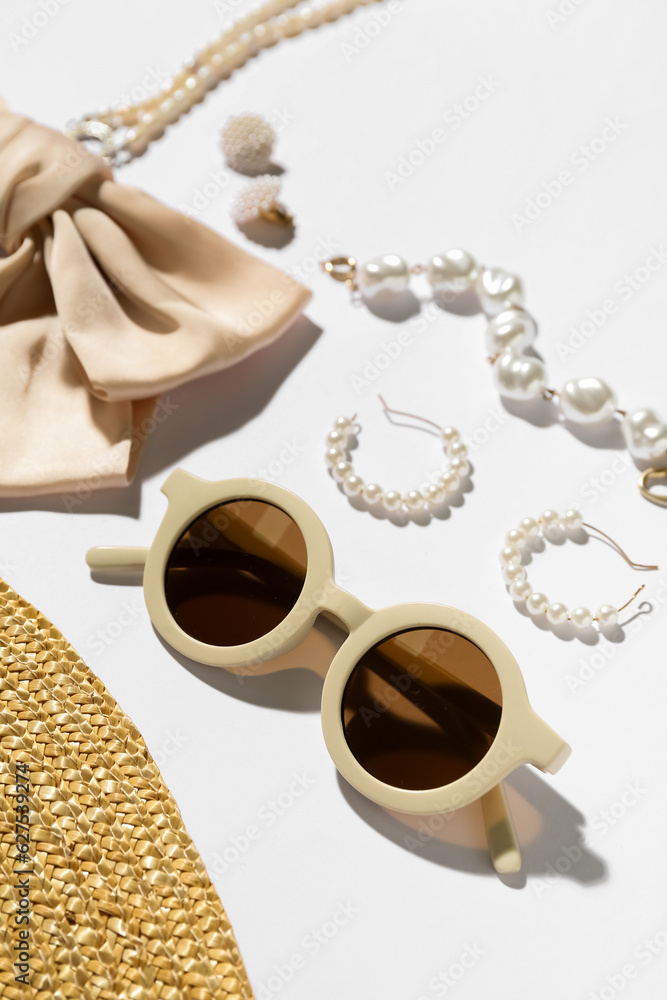 Jewelry with sunglasses and summer hat on white background, closeup