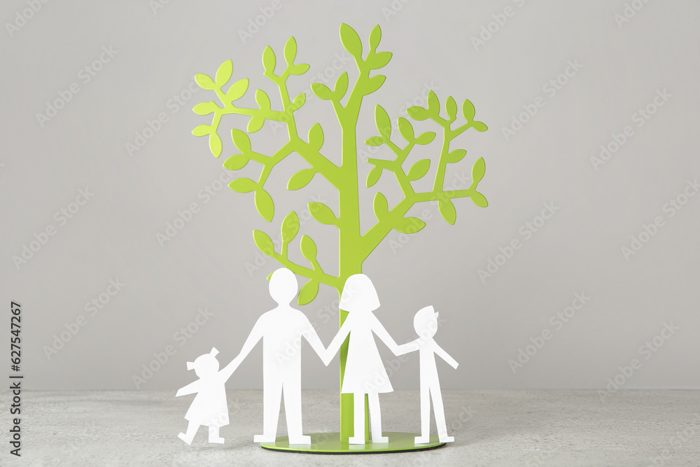 Figures of family with decorative tree on white table