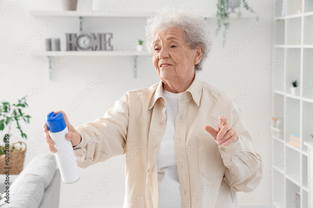 Senior woman with air freshener at home