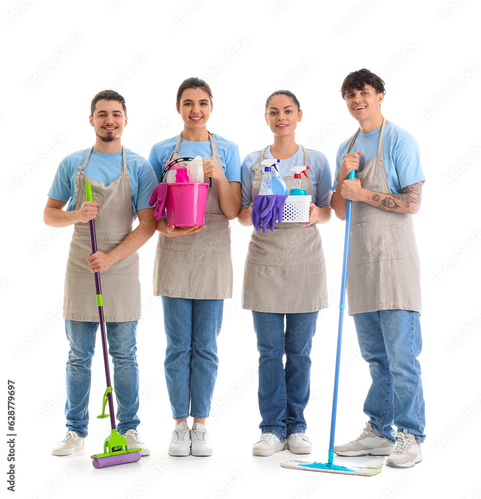 Young janitors with cleaning supplies on white background