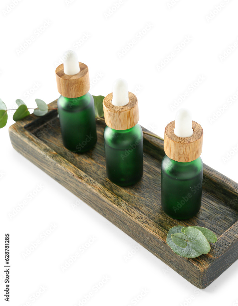 Cosmetic oil with wooden stand and eucalyptus branch on white background