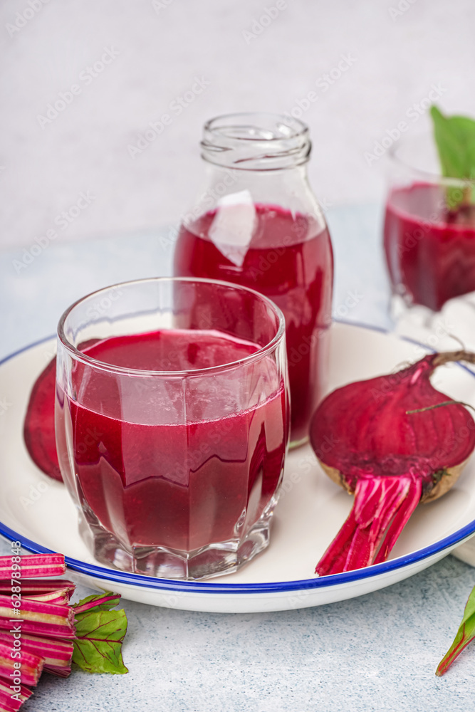 Glass of fresh beetroot juice on light background