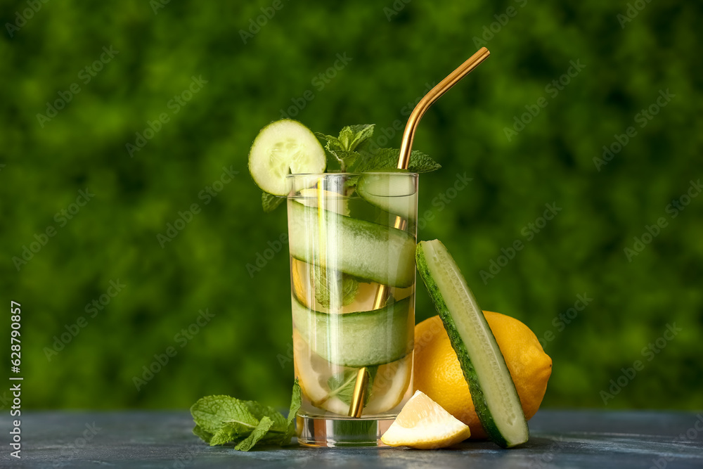 Glass of lemonade with cucumber and mint on black table outdoors