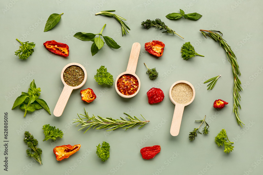 Composition with scoops of spices and fresh herbs on color background