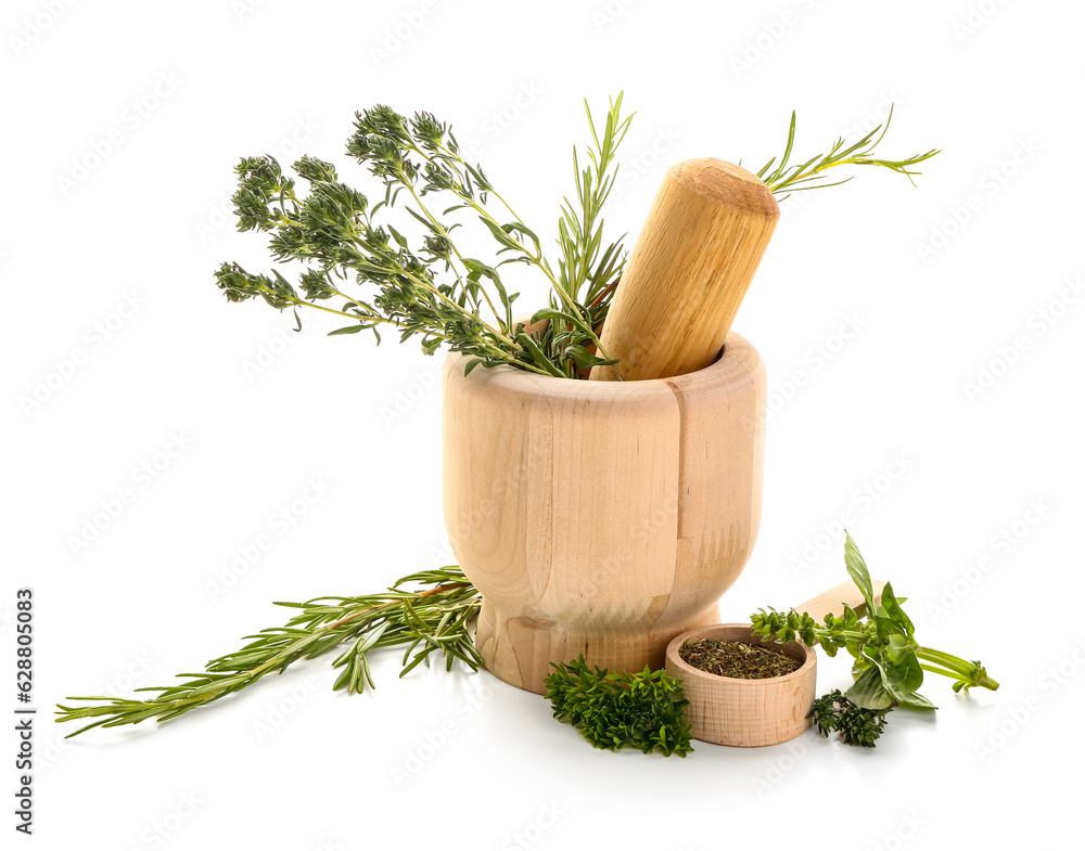 Wooden mortar with different herbs on white background