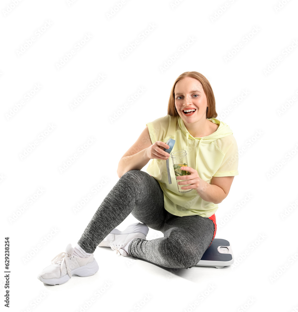Young overweight woman with scales and bottle of water on white background
