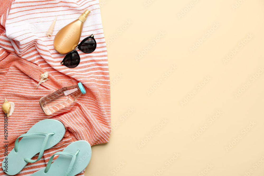 Composition with beach accessories, bottle of drink and sunscreen cream on color background