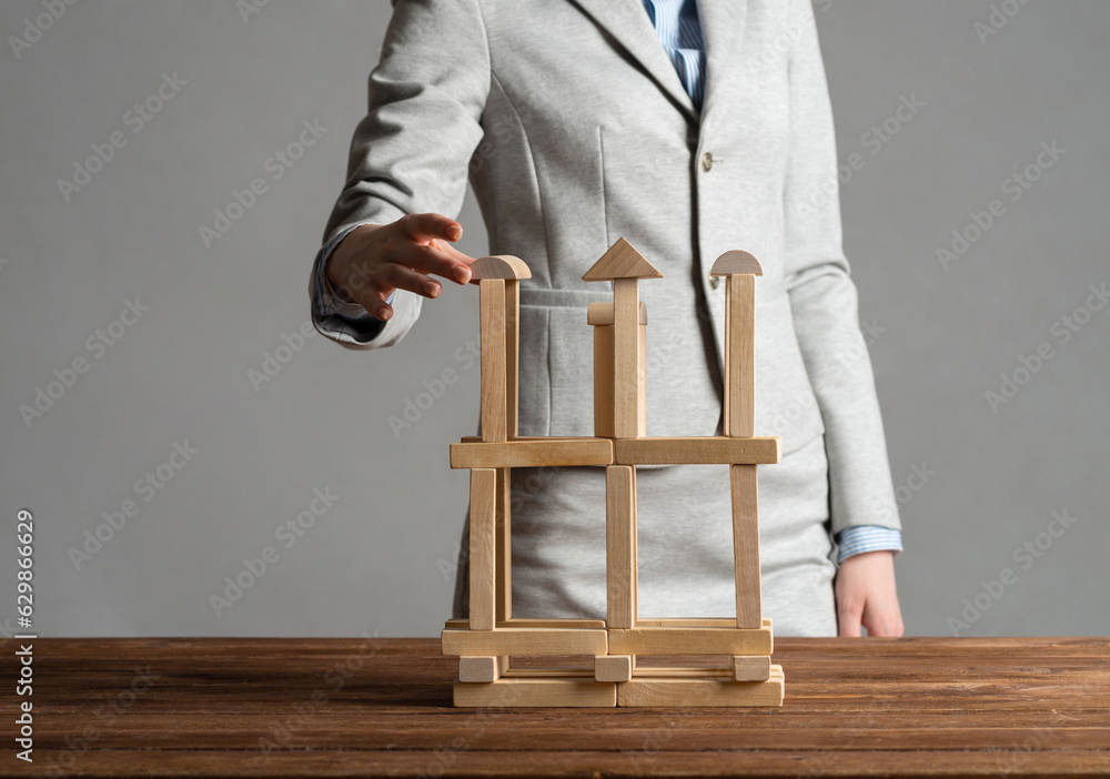 Business woman building tower on table