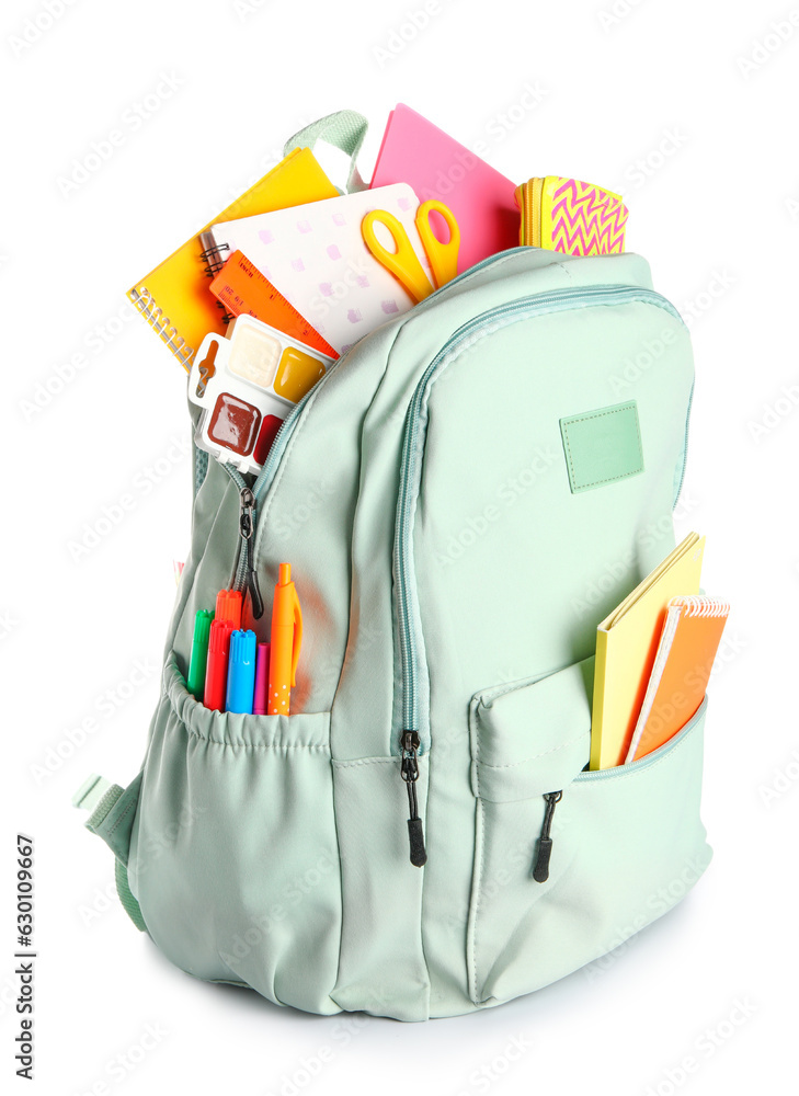 Green school backpack with notebooks, pencil case and scissors on white background