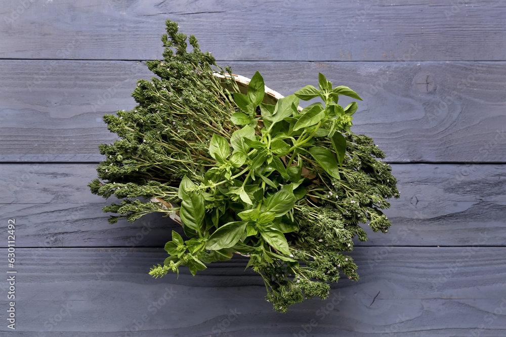 Basket with fresh herbs on dark color background