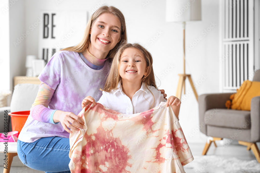 Little girl with her sister and tie-dye t-shirt at home