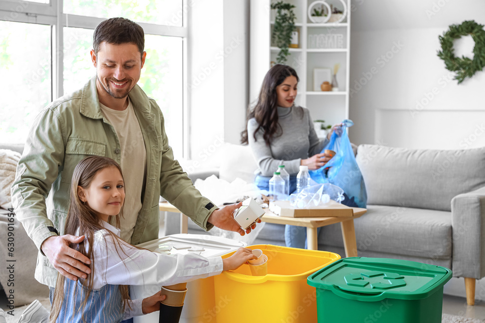 Family sorting paper garbage in recycle bins at home