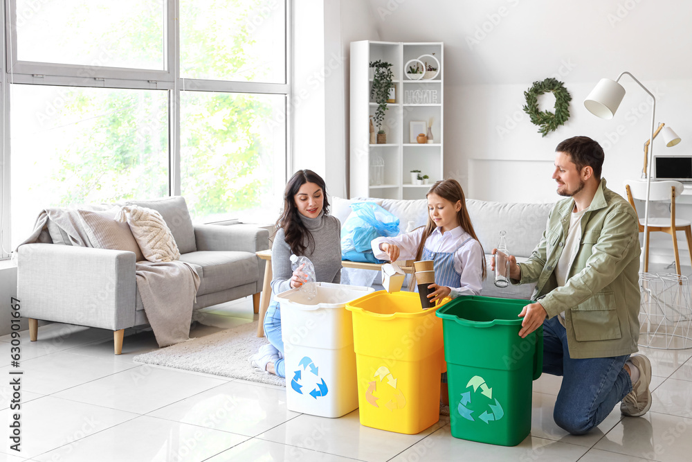 Family sorting garbage in recycle bins at home