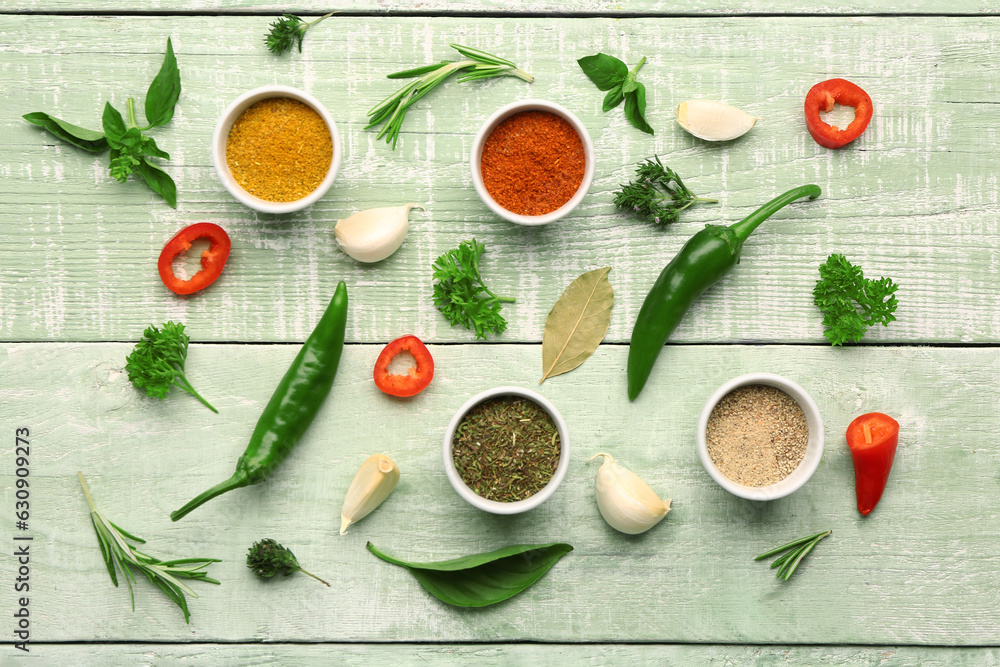 Composition with bowls of fresh spices and herbs on color wooden background
