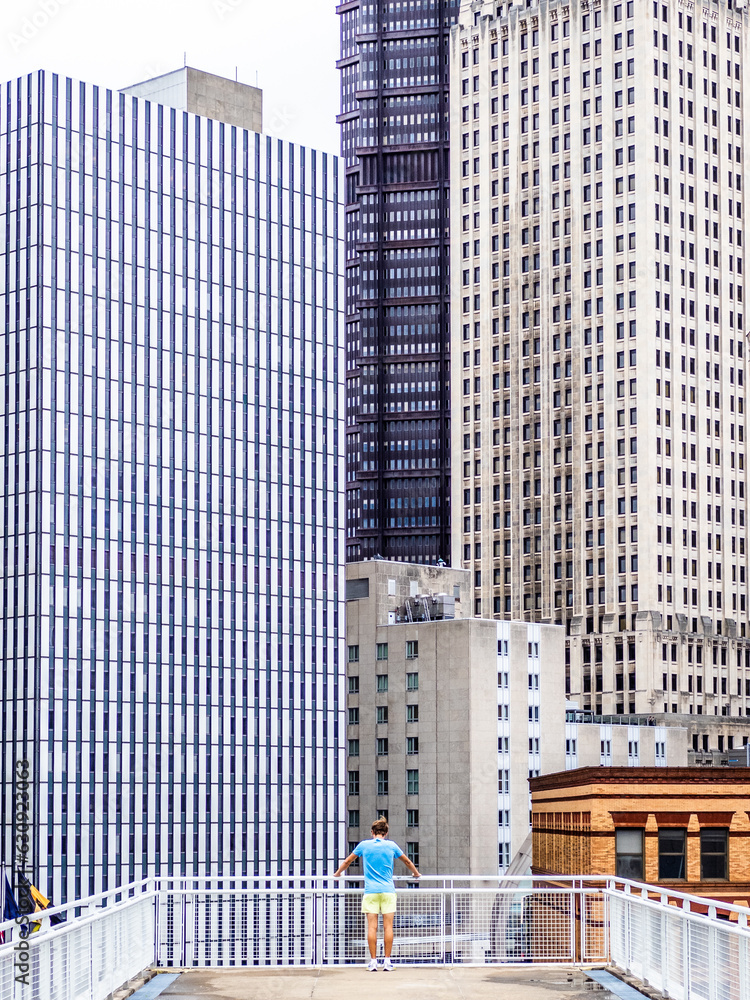 A person is looking at Pittsburgh downtown from the rooftop of Convention Center