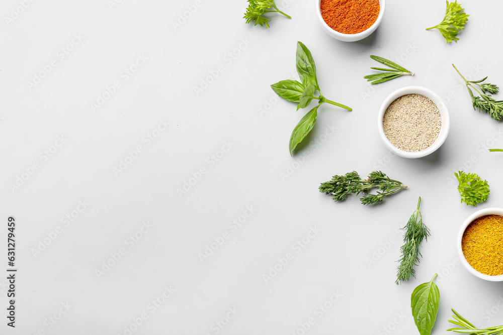 Composition with fresh herbs and different spices on light background