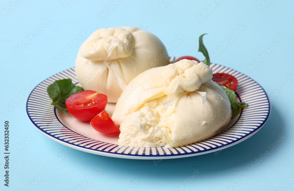 Plate with tasty Burrata cheese on blue background
