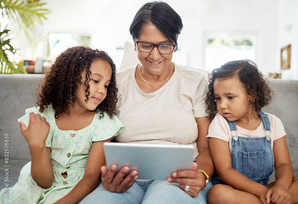 Tablet, bonding and grandmother watching with children enjoying a video or movie together in the liv