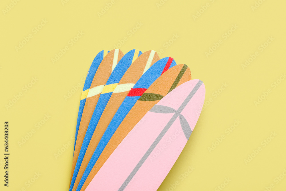Different mini surfboards on yellow background