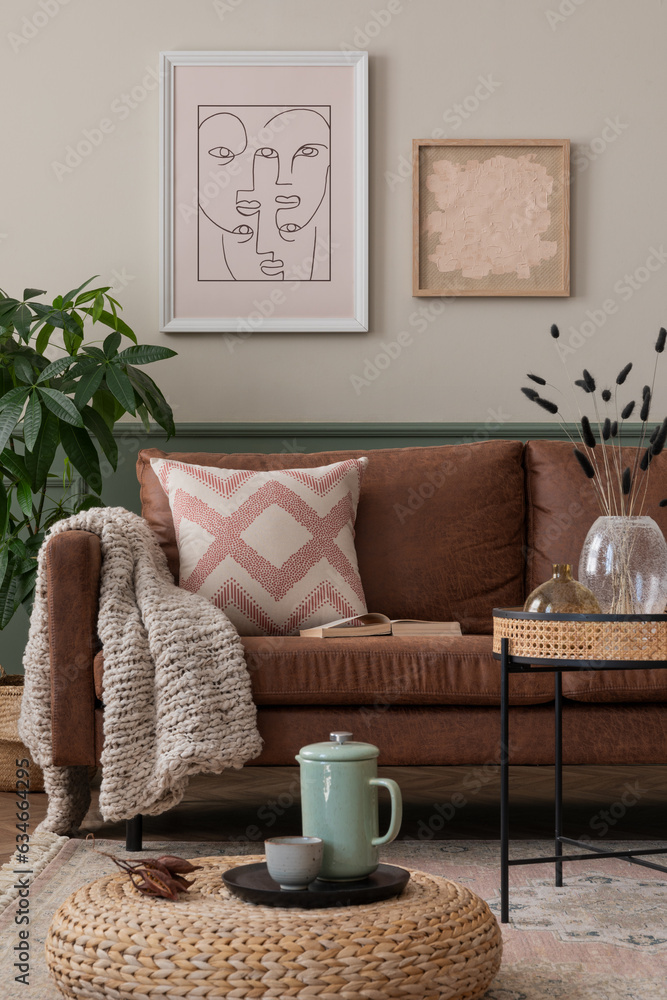 Interior design of cozy living room interior with mock up poster frame, brown sofa, braided pouf, gr
