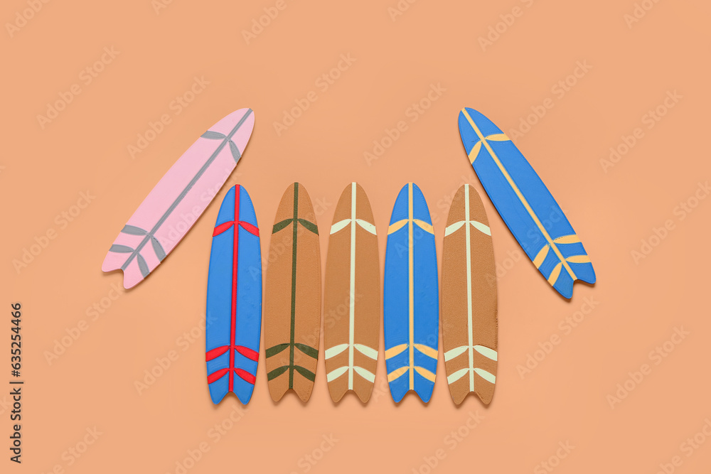 Different mini surfboards on orange background