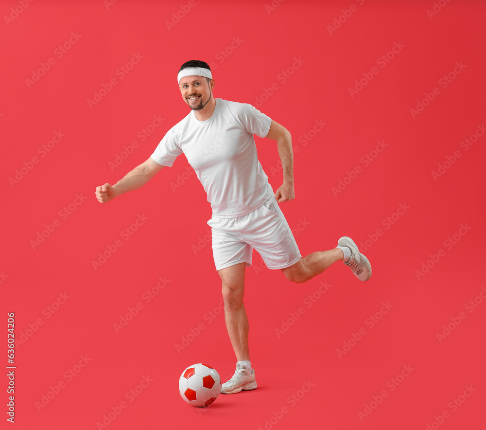 Man playing soccer on red background