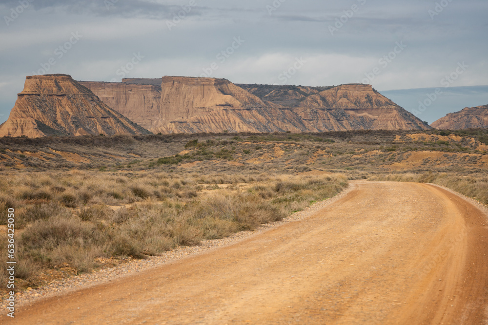 Dirt road on Bardenas Reales desert landscape in Navarra, Spain