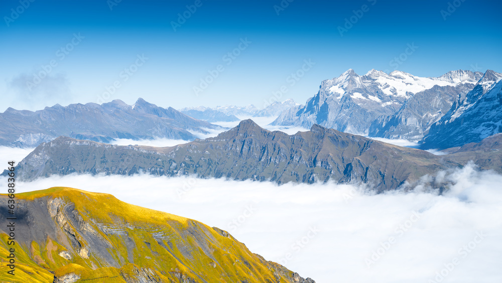 Mountain landscape. View of a high mountain in a valley. Huge sharp rocks and clouds. Landscape in s
