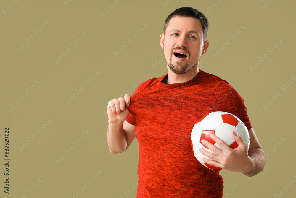 Happy man with soccer ball on color background