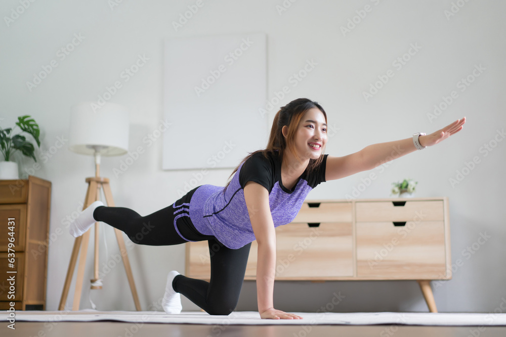Young asian woman doing yoga balance exercise with bird dog pose for healthy lifestyle at home