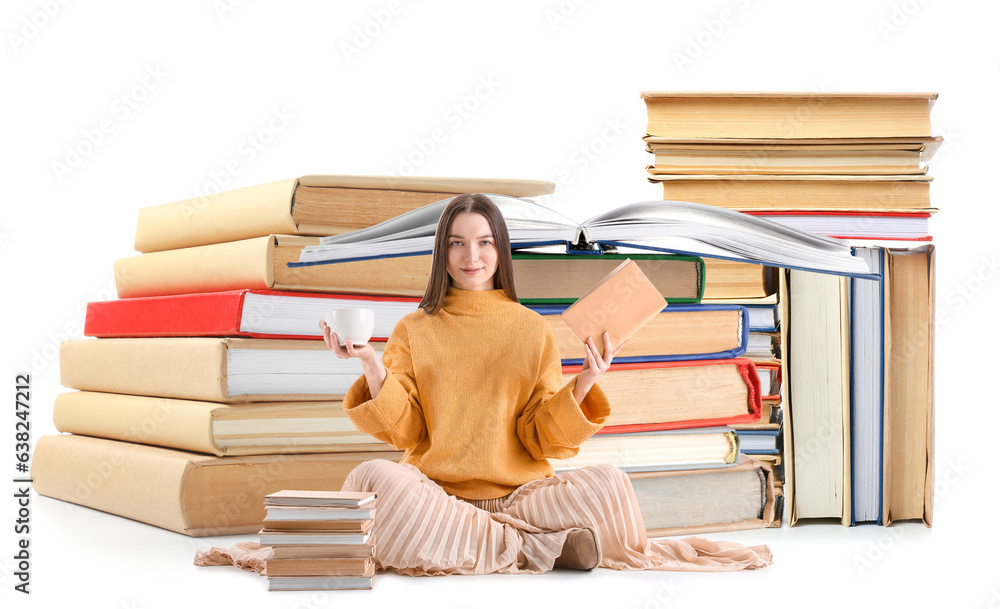 Young woman with cup of cocoa and books sitting on white background