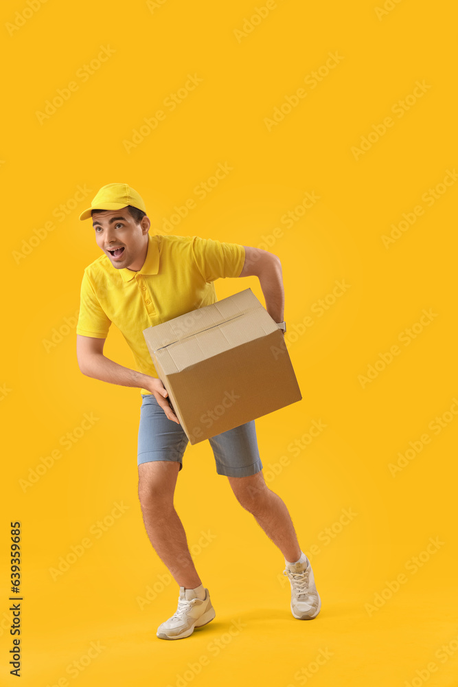 Male courier with parcel running on yellow background