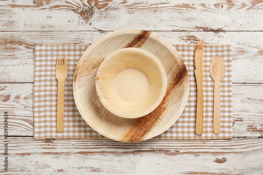 Different tableware on light wooden background