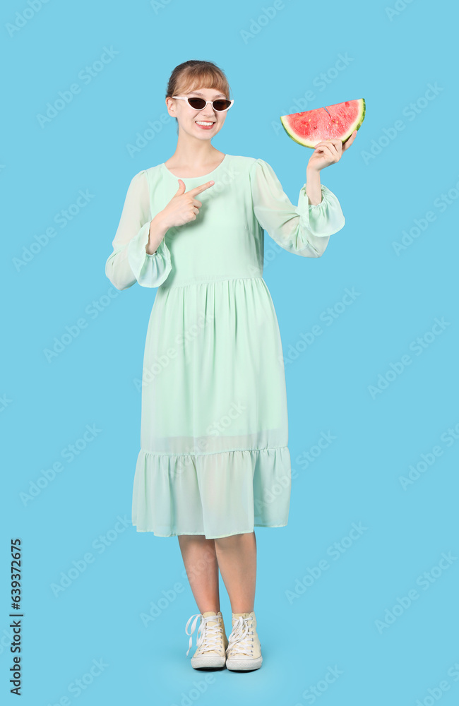Young woman with fresh watermelon on blue background