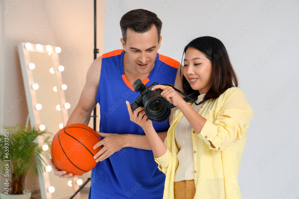 Female photographer working with basketball player in studio