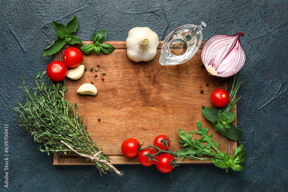 Composition with wooden board, herbs, spices and vegetables on dark color background