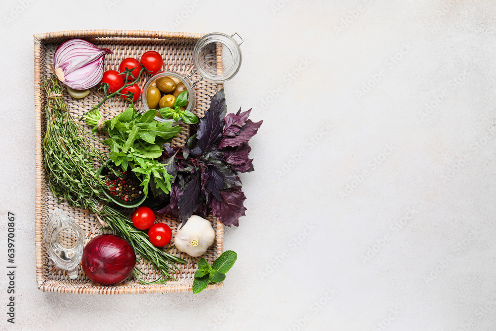 Tray with herbs, spices and vegetables on light background