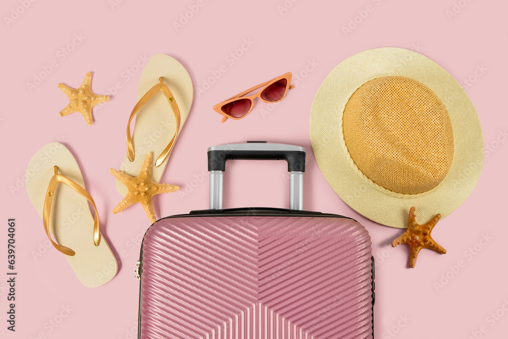 Composition with suitcase, beach accessories and starfishes on color background