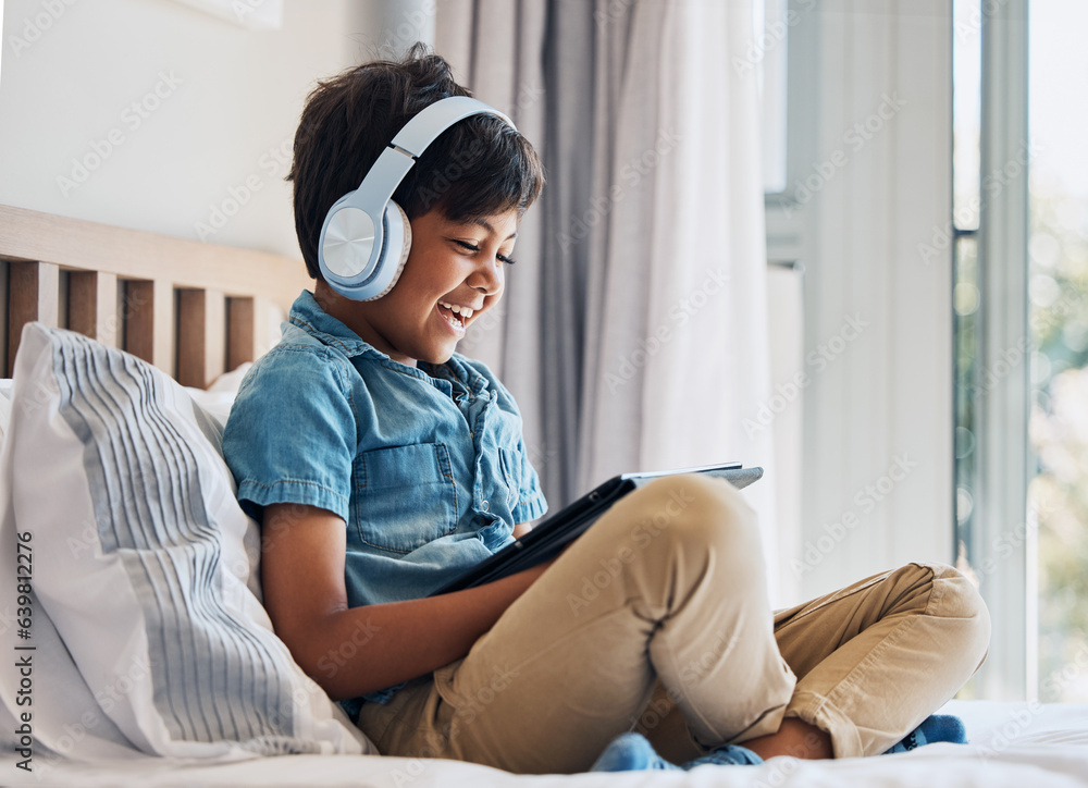 Happy, child and headphones with tablet on bed to watch funny movies, play video games or app. Boy k