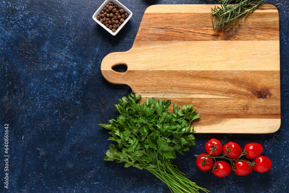 Composition with wooden cutting board, spices, herbs and tomatoes on dark color background