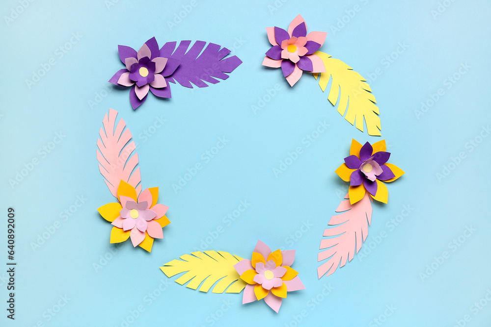 Frame made of colorful origami flowers and leaves on blue background