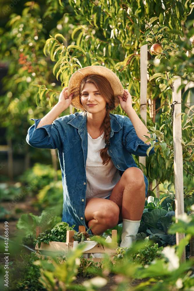 Smiling and sitting. Beautiful young woman is gardening