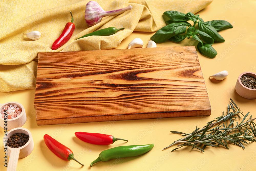 Composition with wooden cutting board, fresh spices and herbs on color background