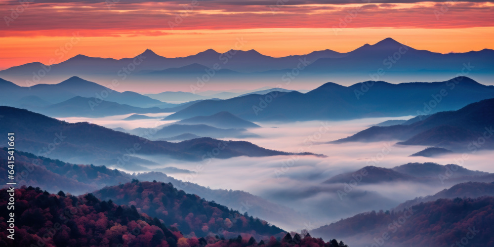 The mountains are shrouded in mist. A twilight shot of autumn mountains under a fading red orange pu
