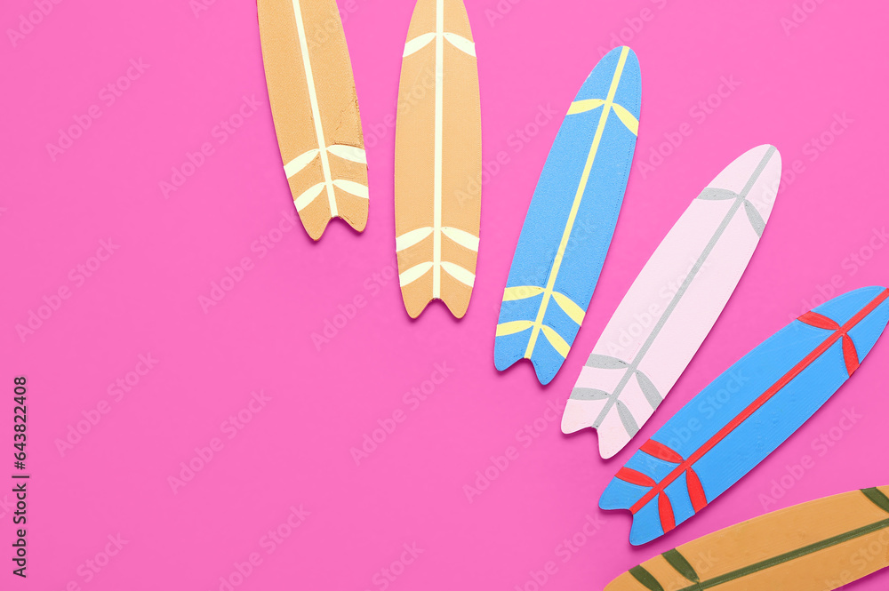 Different mini surfboards on pink background