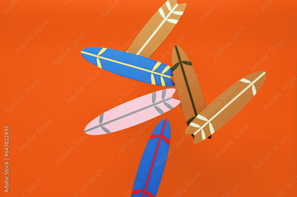 Flying mini surfboards on orange background