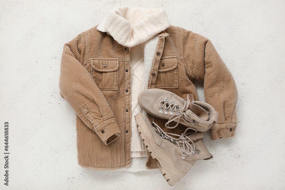 Stylish childrens jacket, sweater and boots on light background